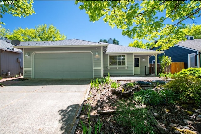 ranch-style home featuring an attached garage, driveway, and fence