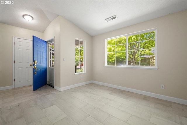 empty room featuring baseboards and vaulted ceiling