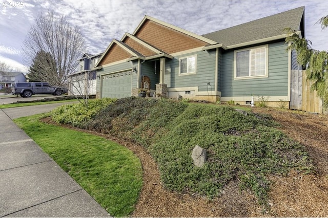 craftsman-style home featuring a garage, driveway, and fence