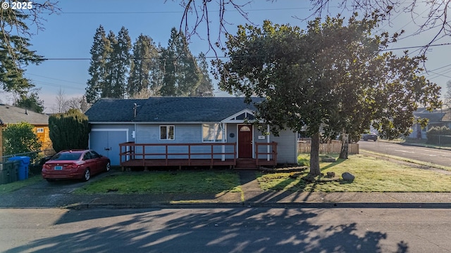 ranch-style house with roof with shingles, a deck, and a front yard