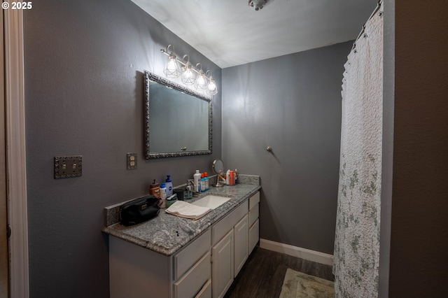 bathroom featuring wood finished floors, vanity, and baseboards