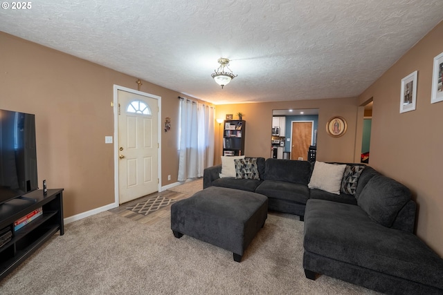 living area with carpet flooring, a textured ceiling, and baseboards