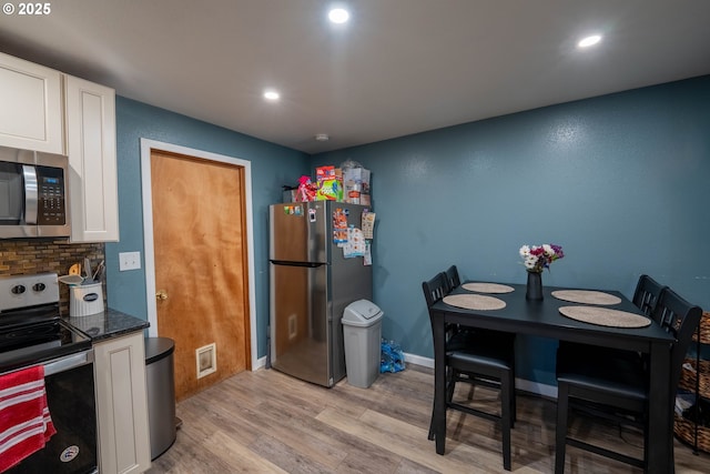 kitchen with recessed lighting, stainless steel appliances, white cabinets, light wood-type flooring, and decorative backsplash