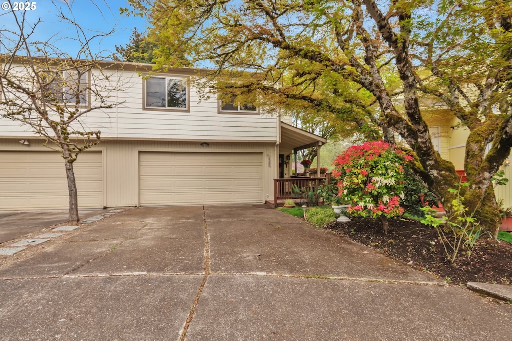 view of front facade featuring a porch, a garage, and concrete driveway