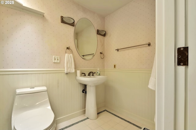 18005 SW Monte Verdi Blvd, Beaverton, OR 97007 - bathroom featuring wainscoting, wallpapered walls, toilet, tile patterned floors, and baseboards