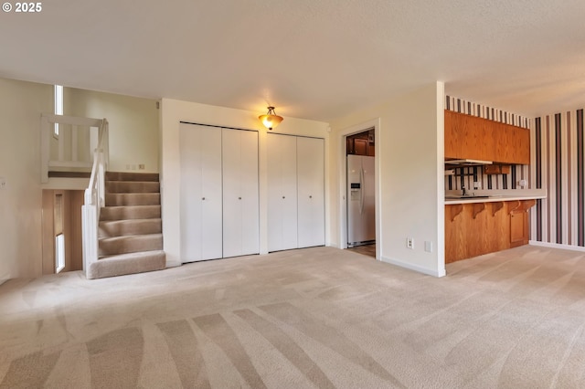 18005 SW Monte Verdi Blvd, Beaverton, OR 97007 - unfurnished living room featuring light colored carpet and stairs