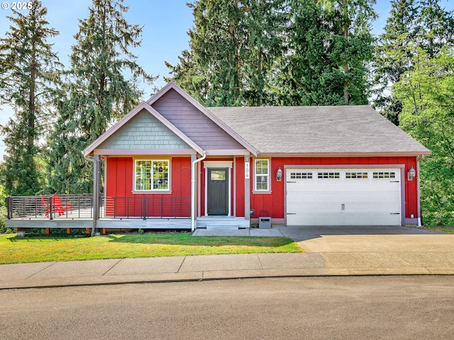 104 S Pl, Astoria, OR 97103 - view of front facade with board and batten siding, an attached garage, concrete driveway, and roof with shingles
