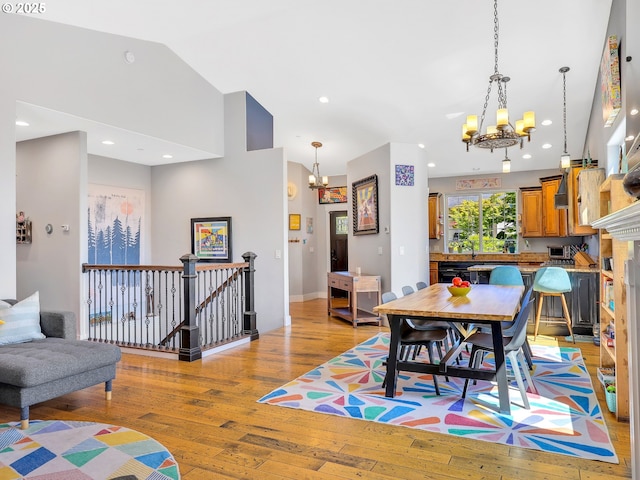 104 S Pl, Astoria, OR 97103 - dining space with a chandelier, light wood-type flooring, and vaulted ceiling