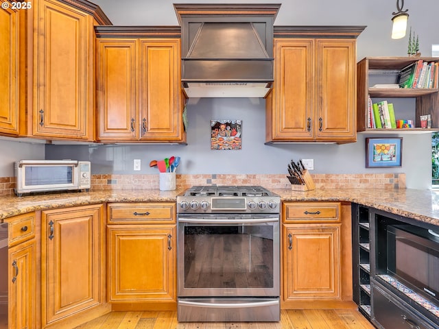 104 S Pl, Astoria, OR 97103 - kitchen featuring stainless steel appliances, custom exhaust hood, light wood-type flooring, and light stone countertops