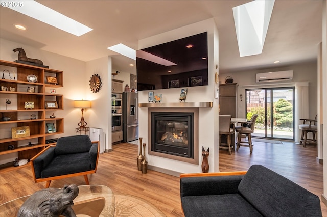 1342 11th St SW, Bandon, OR 97411 - living area featuring a skylight, a wall unit AC, a glass covered fireplace, and light wood-style flooring