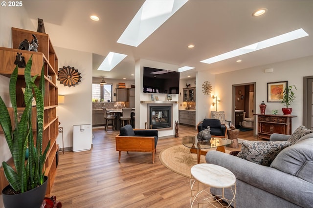 1342 11th St SW, Bandon, OR 97411 - living area with a skylight, light wood-type flooring, recessed lighting, and a multi sided fireplace