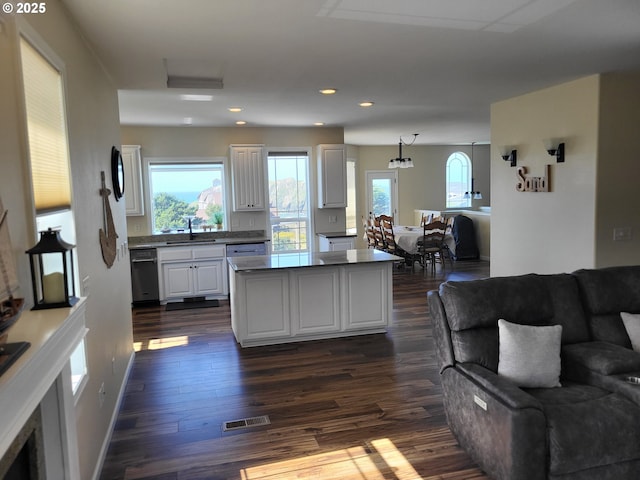 54179 Gould Rd, Bandon, OR 97411 - kitchen featuring a sink, black dishwasher, white cabinets, a center island, and dark wood-style floors