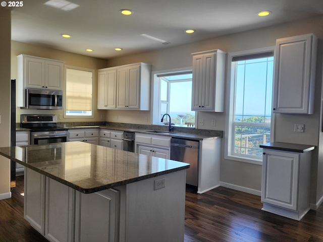 54179 Gould Rd, Bandon, OR 97411 - kitchen featuring stainless steel appliances, a sink, baseboards, white cabinets, and dark wood-type flooring