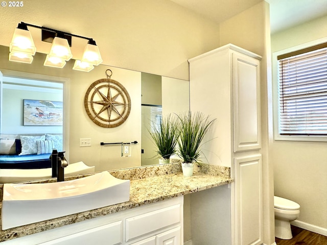 54179 Gould Rd, Bandon, OR 97411 - ensuite bathroom featuring vanity, toilet, wood finished floors, and baseboards