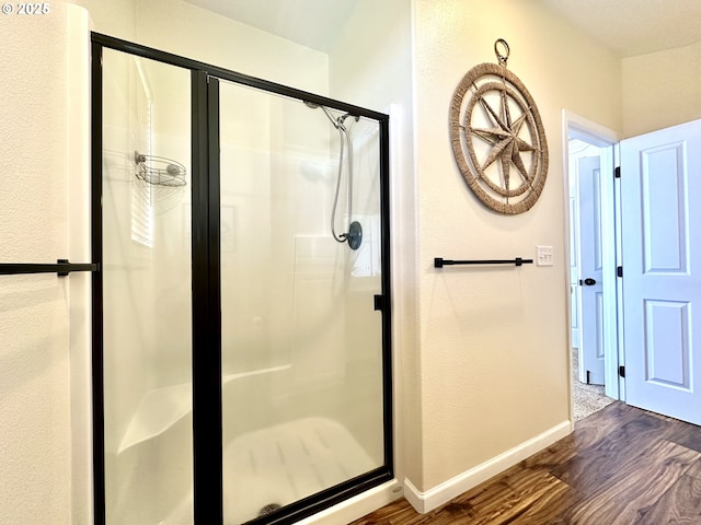 54179 Gould Rd, Bandon, OR 97411 - full bath featuring wood finished floors, a stall shower, and baseboards