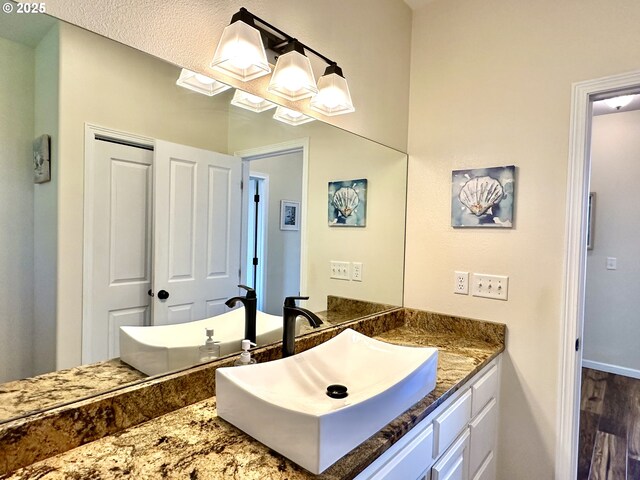 54179 Gould Rd, Bandon, OR 97411 - bathroom featuring vanity, wood finished floors, and baseboards