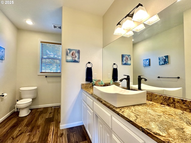 54179 Gould Rd, Bandon, OR 97411 - bathroom with wood finished floors, baseboards, vanity, and toilet