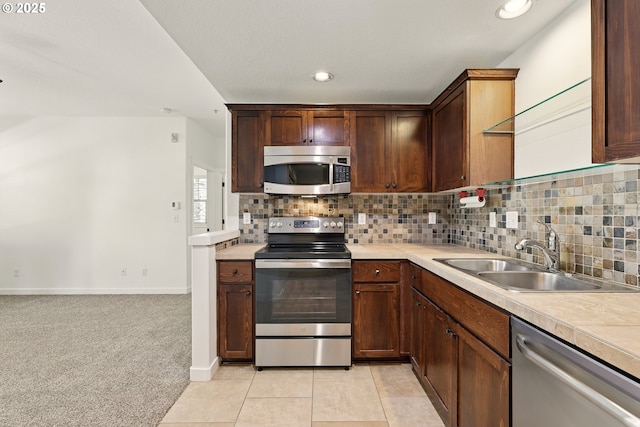 672 NE Newstead Ln, Hillsboro, OR 97006 - kitchen featuring appliances with stainless steel finishes, a sink, light countertops, tasteful backsplash, and recessed lighting