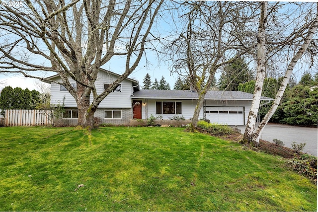 tri-level home with fence, a garage, aphalt driveway, and a front lawn