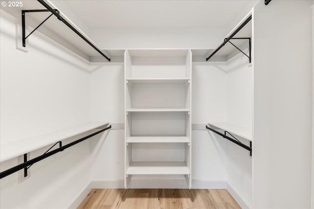 7143 SW Sagert St Unit 106, Tualatin, OR 97062 - unfurnished bedroom featuring a wall mounted air conditioner, light wood-type flooring, recessed lighting, baseboards, and a spacious closet