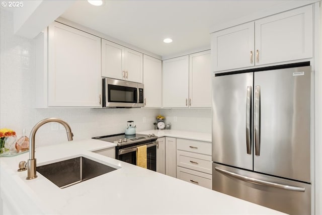 7143 SW Sagert St Unit 106, Tualatin, OR 97062 - kitchen with appliances with stainless steel finishes, a sink, light countertops, white cabinetry, and recessed lighting