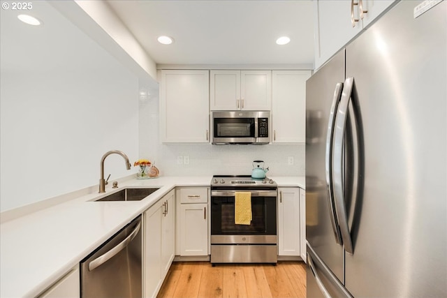 7143 SW Sagert St Unit 106, Tualatin, OR 97062 - kitchen with stainless steel appliances, a sink, light countertops, recessed lighting, and white cabinetry