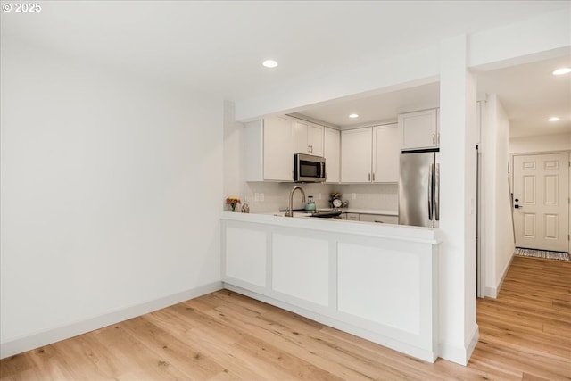 7143 SW Sagert St Unit 106, Tualatin, OR 97062 - kitchen featuring stainless steel appliances, decorative backsplash, baseboards, recessed lighting, and light countertops