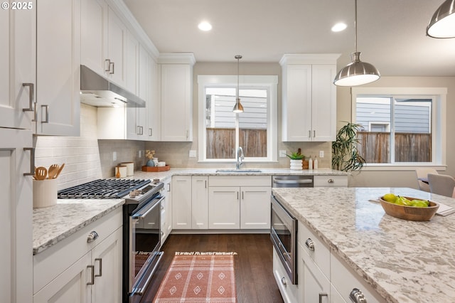 kitchen featuring appliances with stainless steel finishes, decorative light fixtures, and white cabinets