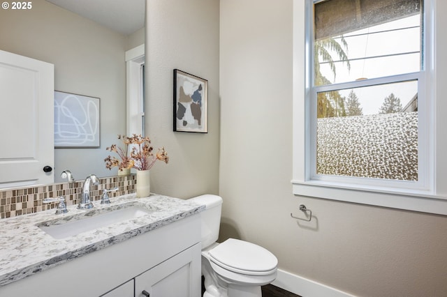 bathroom with tasteful backsplash, vanity, and toilet