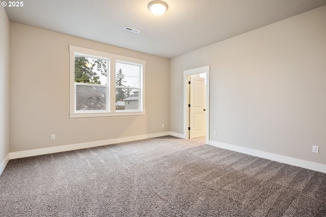 carpeted spare room with a textured ceiling