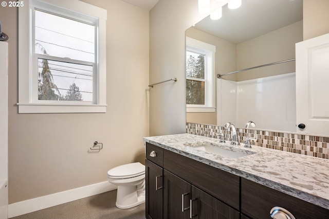 bathroom with tasteful backsplash, vanity, toilet, and a shower