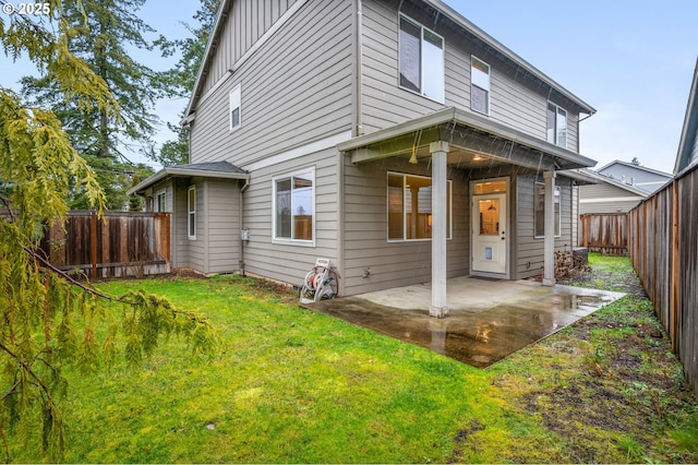 rear view of property featuring a yard and a patio area