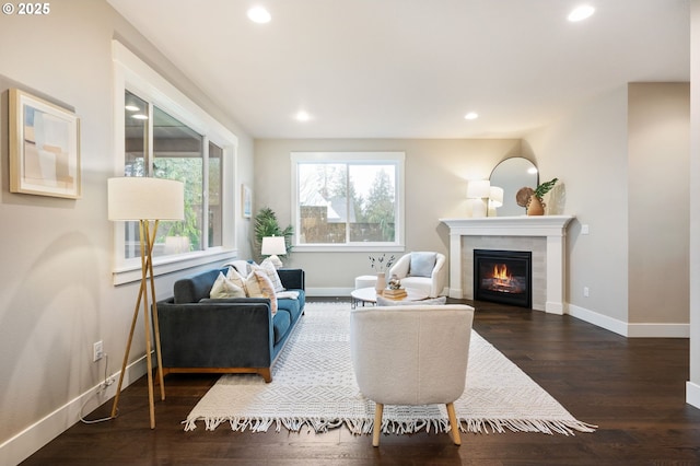 living room with dark wood-type flooring and a tile fireplace