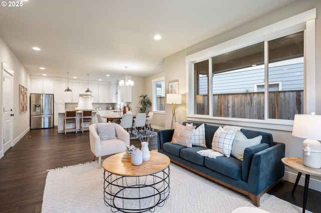 living room with dark wood-type flooring and a chandelier