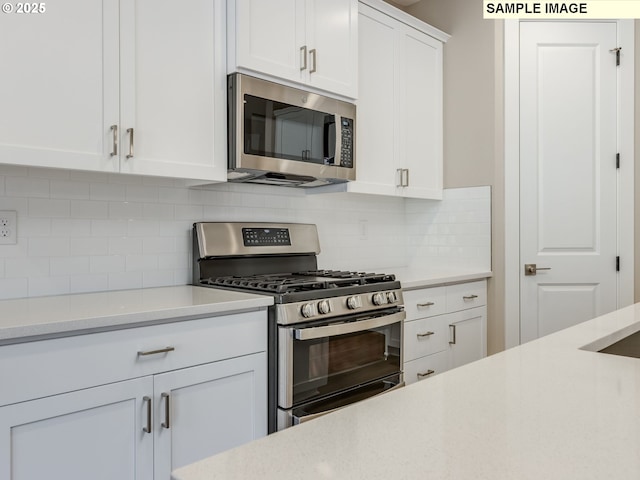 736 NW 178th Way, Ridgefield, WA 98642 - kitchen with appliances with stainless steel finishes, light countertops, white cabinets, and decorative backsplash