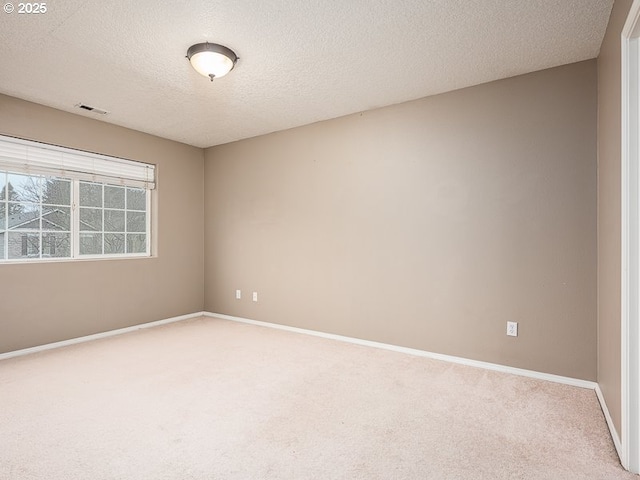 carpeted spare room with a textured ceiling