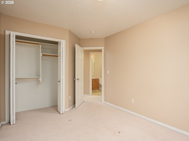 unfurnished bedroom with light colored carpet, a closet, and a textured ceiling