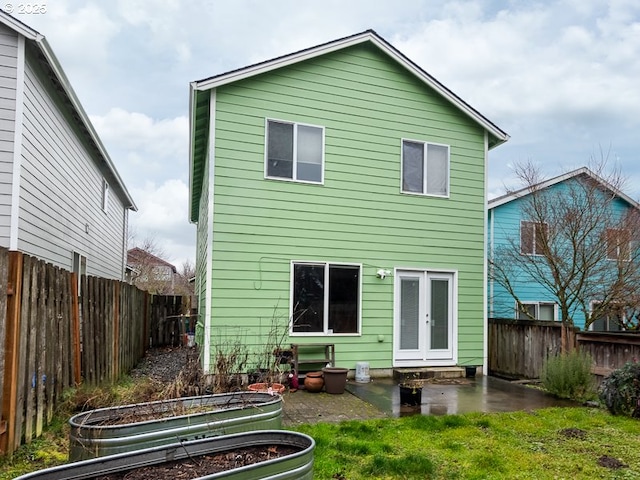 back of house featuring a yard and french doors