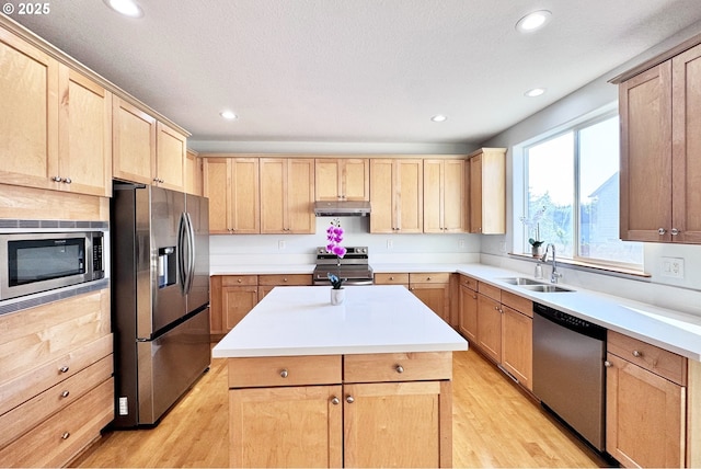 13007 SE Raymond Ct, Portland, OR 97236 - kitchen featuring stainless steel appliances, a sink, light brown cabinets, under cabinet range hood, and light wood finished floors