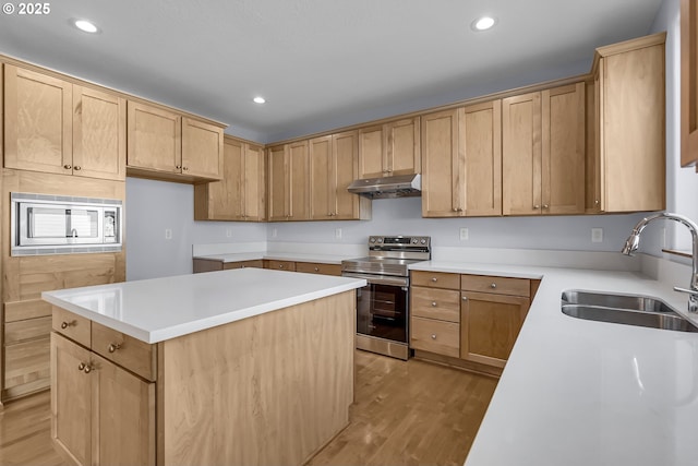 13007 SE Raymond Ct, Portland, OR 97236 - kitchen with appliances with stainless steel finishes, a sink, light wood-type flooring, a kitchen island, and under cabinet range hood