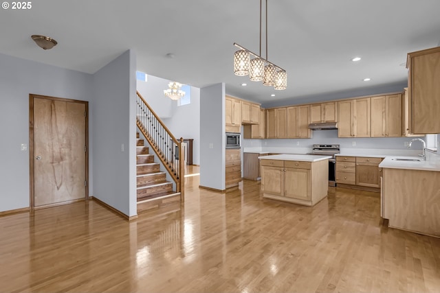 13007 SE Raymond Ct, Portland, OR 97236 - kitchen with a sink, under cabinet range hood, a chandelier, stainless steel appliances, and light countertops