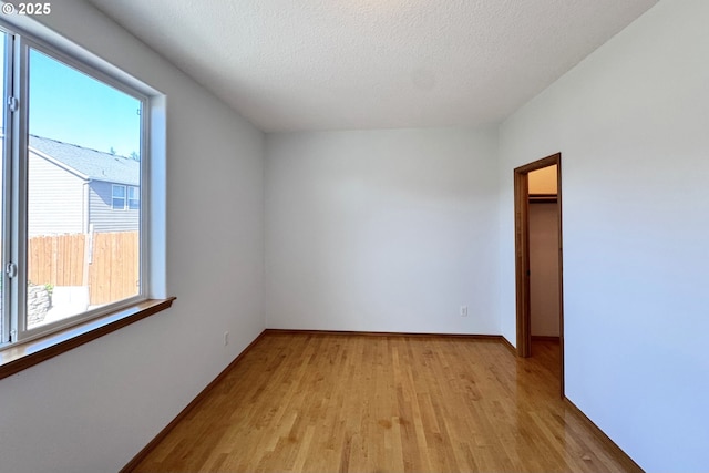 13007 SE Raymond Ct, Portland, OR 97236 - spare room featuring light wood-type flooring, baseboards, and a textured ceiling