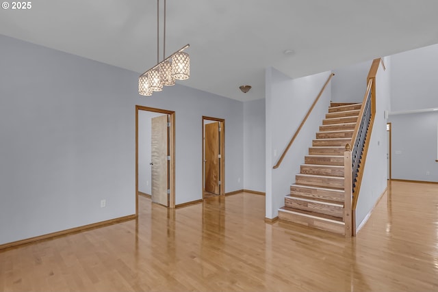 13007 SE Raymond Ct, Portland, OR 97236 - spare room featuring wood finished floors, stairway, a chandelier, and baseboards