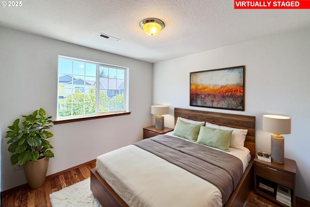13007 SE Raymond Ct, Portland, OR 97236 - bedroom with wood finished floors, a textured ceiling, and baseboards
