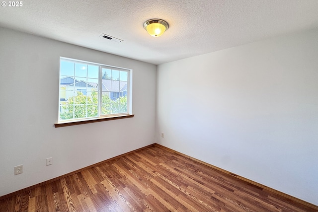 13007 SE Raymond Ct, Portland, OR 97236 - unfurnished room with wood finished floors, baseboards, and a textured ceiling