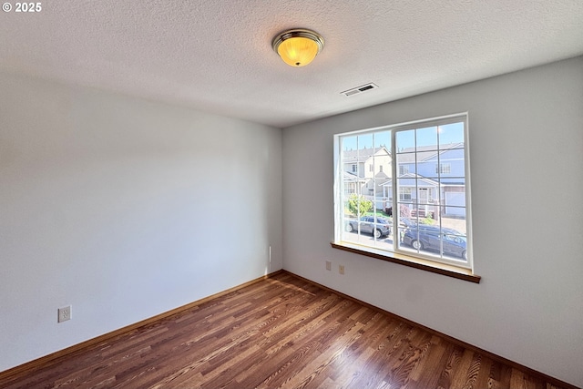 13007 SE Raymond Ct, Portland, OR 97236 - empty room featuring wood finished floors, baseboards, and a textured ceiling