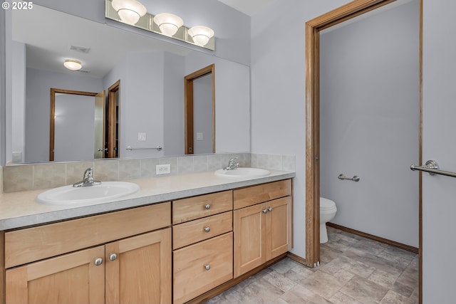 13007 SE Raymond Ct, Portland, OR 97236 - full bath featuring double vanity, toilet, stone finish floors, and baseboards