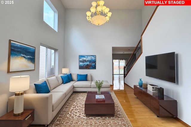 13007 SE Raymond Ct, Portland, OR 97236 - living room featuring a chandelier, light wood finished floors, a towering ceiling, and stairway