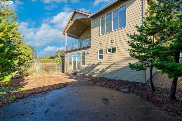703 SE Keel Ave, Lincoln City, OR 97367 - rear view of house featuring entry steps, a patio, and a balcony