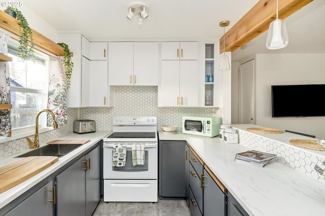 kitchen with white appliances, white cabinets, a sink, gray cabinets, and backsplash